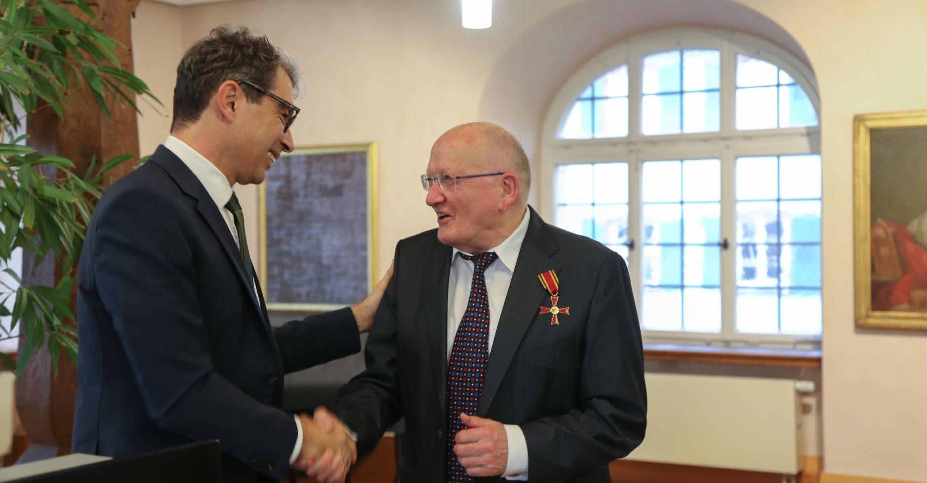 Staatssekretär Dr. Andre Baumann gratuliert Edmund Hensle zum Bundesverdienstkreuz