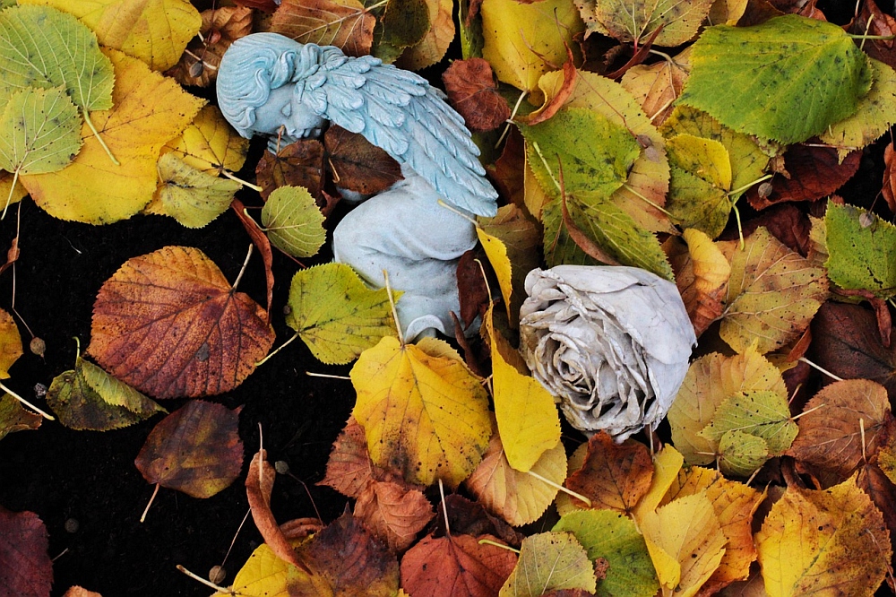 Schlafende Engelsfigur im Herbstlaub